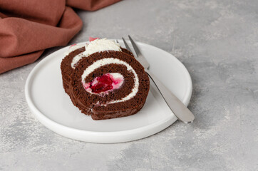 Black forest chocolate cake roll with whipped cream and cherry filling on a gray background. Copy space. - obrazy, fototapety, plakaty