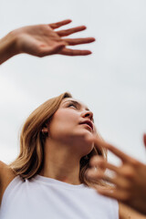 Fototapeta premium Young caucasian woman dancing outdoor gesturing with hands feeling free