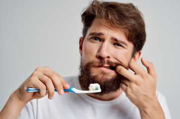 man toothbrush in hand hygiene clean teeth light background