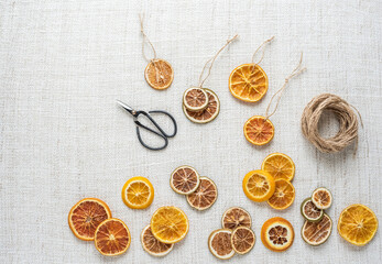 Weihnachtsschmuck getrocknete Orangenscheiben selber machen mit Bindfaden und Schere