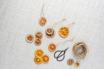 Weihnachtsschmuck getrocknete Orangenscheiben selber machen mit Bindfaden und Schere