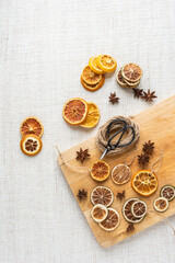 Weihnachtsschmuck getrocknete Orangenscheiben und Anis, Flatlay mit Schere Bindfaden und Holzablett