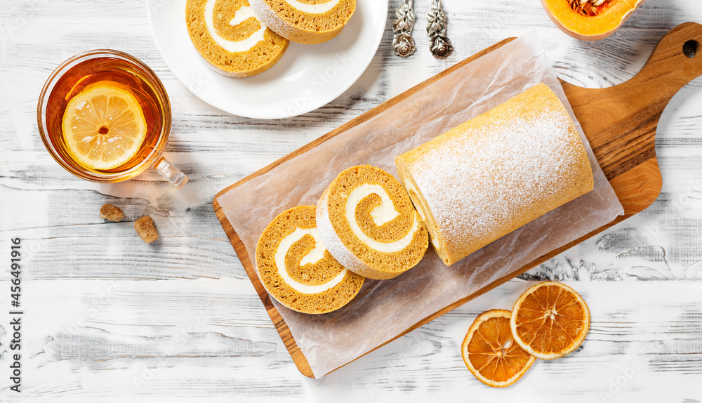 Wall mural pumpkin cake roll with cream cheese filling. autumn baking. white wooden background, top view