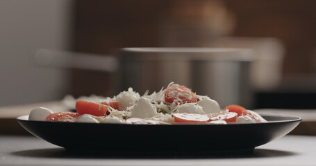 sprinkle penne with mozzarella, tomatoes and pesto with aged grated cheese