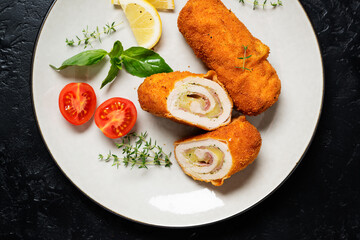 French traditional cuisine crispy, creamy chicken cordon bleu on black background. top view  