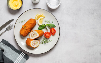 French traditional cuisine crispy, creamy chicken cordon bleu on gray background. top view. space...