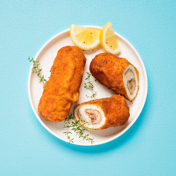 French traditional cuisine crispy, creamy chicken cordon bleu on blue background. top view. 