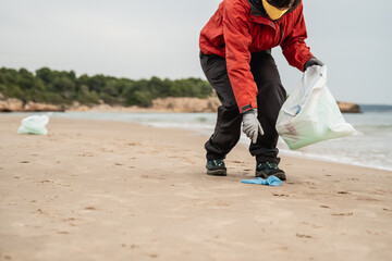 Young volunteer clean up plastic and trash waste from the beach at the beach - Environment and...