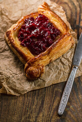 Homemade puff pastry with cherry on old black cooking sheet. Sweet tasty dessert. 