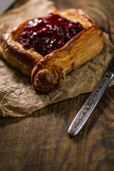 Homemade puff pastry with cherry on old black cooking sheet. Sweet tasty dessert. 