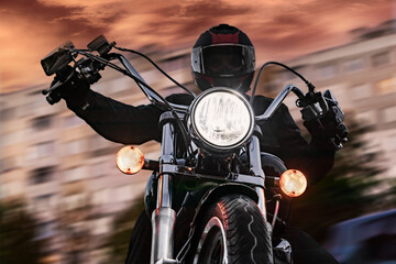 A man biker on a motorcycle in the evening on a city street. Close-up. Night motorcyclist.