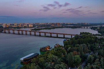Evening Kiev from a bird's eye view. Architectural monuments. The light of lanterns and evening lights. City on the Dnieper. White buildings. Sunset.