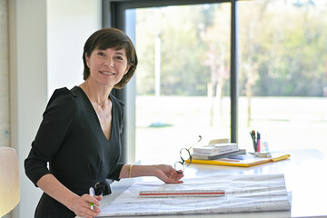 Portrait of a female architect sitting at her desk working on a new construction project