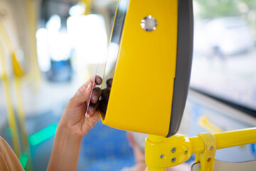 Woman paying conctactless with card for public transport bus