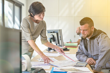 Obraz premium Meeting between the architect and the works manager at the office to discuss the progress of the site and check compliance with the plans