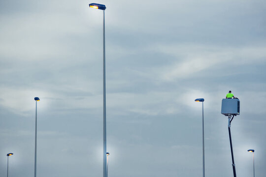 Light Pole Repairing. Worker In Lift Bucket Installing New Lights