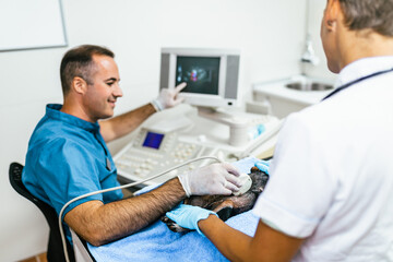 Obraz premium Male and female veterinarians are examining a sick dog in animal clinic.