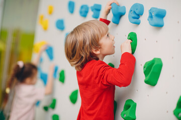 Kid child boy at climbing wall. Children sport, healthy lifestyle in kindergarten or sport center...