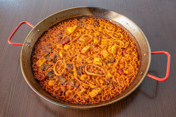 Delicious Valencian squid fideua cooked in a paella pan