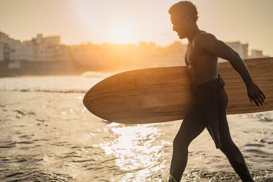 Afro Surfer Having Fun Surfing During Sunset Time - African Man Enjoying Surf Day - Extreme Sport Lifestyle People Concept