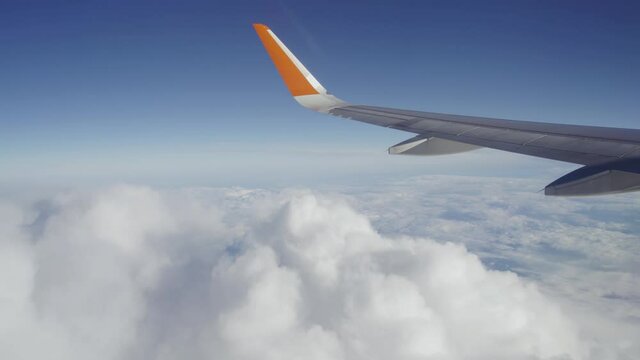 Airplane wing and thick white clouds. Airplane window. Flight abroad. Travel and tourism.