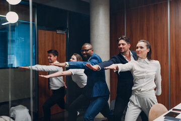 Businessman and businesswoman team doing warm up and yoga exercises before office meeting. Business...