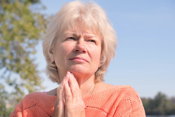 Portrait of a pensive senior woman in autumn park