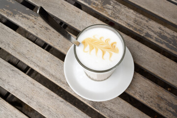 Latte macchiato with latte art on a wooden table 