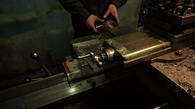 a robot on an old lathe grooving a metal part in a dark workshop	