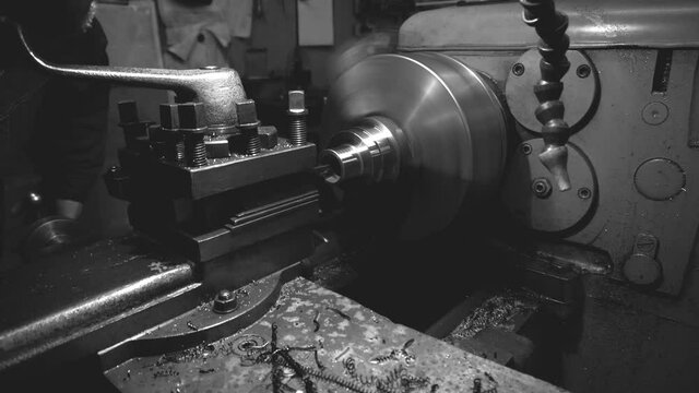 a robot on an old lathe grooving a metal part in a dark workshop	