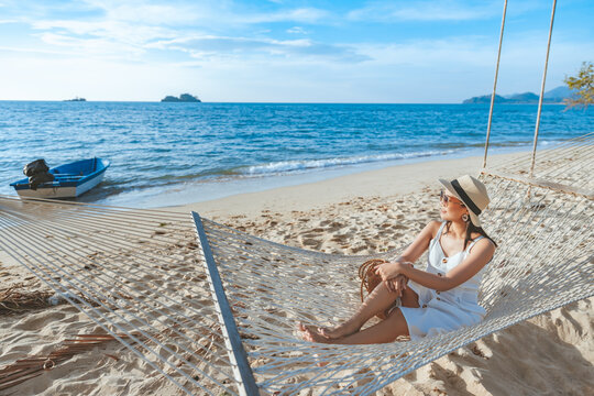 Traveler asian woman relax in hammock on summer beach Trad Thailand