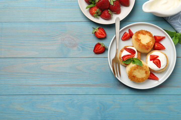 Delicious cottage cheese pancakes with strawberries, honey and sour cream on light blue wooden table, flat lay. Space for text