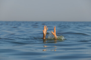 Drowning woman reaching for help in sea