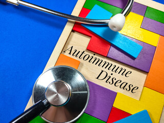 Medical and healthcare concept.Text Autoimmune Disease wiriting on colored wooden puzzle with clock...
