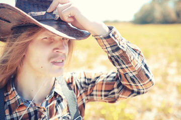Cowboy with hat in a field in autumn