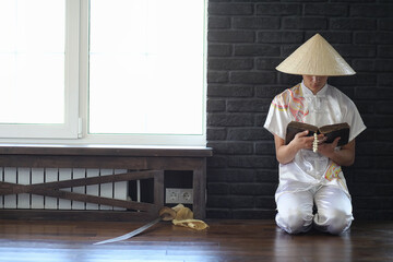 Asian boy in kimono reading an old book