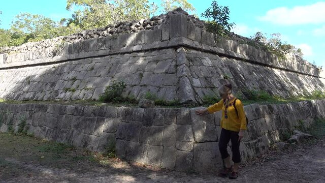 Woman tourist walks around the Temple of warriors, a thousand pillars in Chichen Itza, Yucatan, Mexico on archeological grounds.