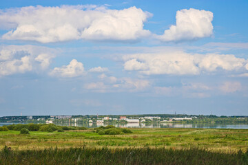 Fototapeta premium Summer landscape - a city on the lake, a rural field.