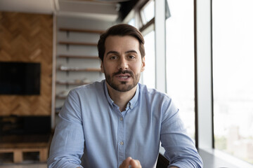 Obraz premium Headshot portrait of young Caucasian man look at camera talk speak on video call with client customer. Millennial male coach or trainer have webcam digital virtual event. Communication concept.