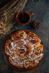 Freshly baked sweet buns on black board on grey stone background