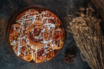 Freshly baked sweet buns on black board on grey stone background