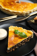 Piece of delicious pie with minced meat, basil and sauce served on table, closeup