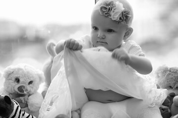 Child in the children's room. The kid is sitting on the windowsill at the window. Happy child.