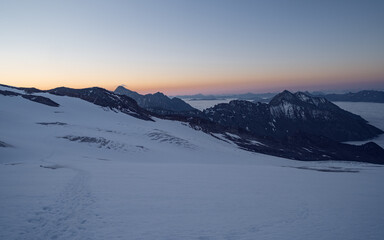 Obraz premium Amazing morning, fog in the valley and illuminated glacial mountains. Trek to Grossvenediger glacier in Hohe Tauern national park, Austria