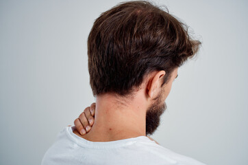 bearded man in a white t-shirt stress medicine pain in the neck studio treatment