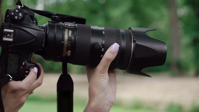 Woman photographer takes photographs outdoors. Girl with photo camera.