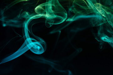 Abstract colored smoke moves on dark background. Wallpaper. Personal vaporizers fragrant steam. Concept of alternative non-nicotine smoking. E-cigarette. Texture. Design elements.