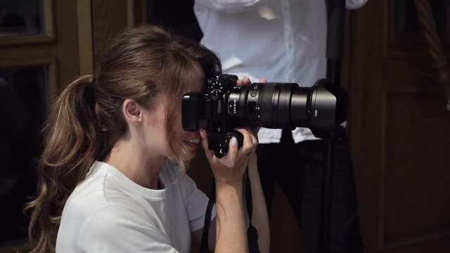 Woman photographer takes photographs outdoors. Girl with photo camera.