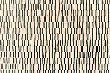 a wall decorated with small rectangular tiles - each one with a black line drawn