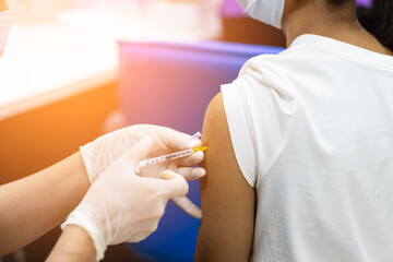 doctor hand holding syringe and using cotton before make injection to patient in medical mask. Covid-19 or coronavirus vaccine.